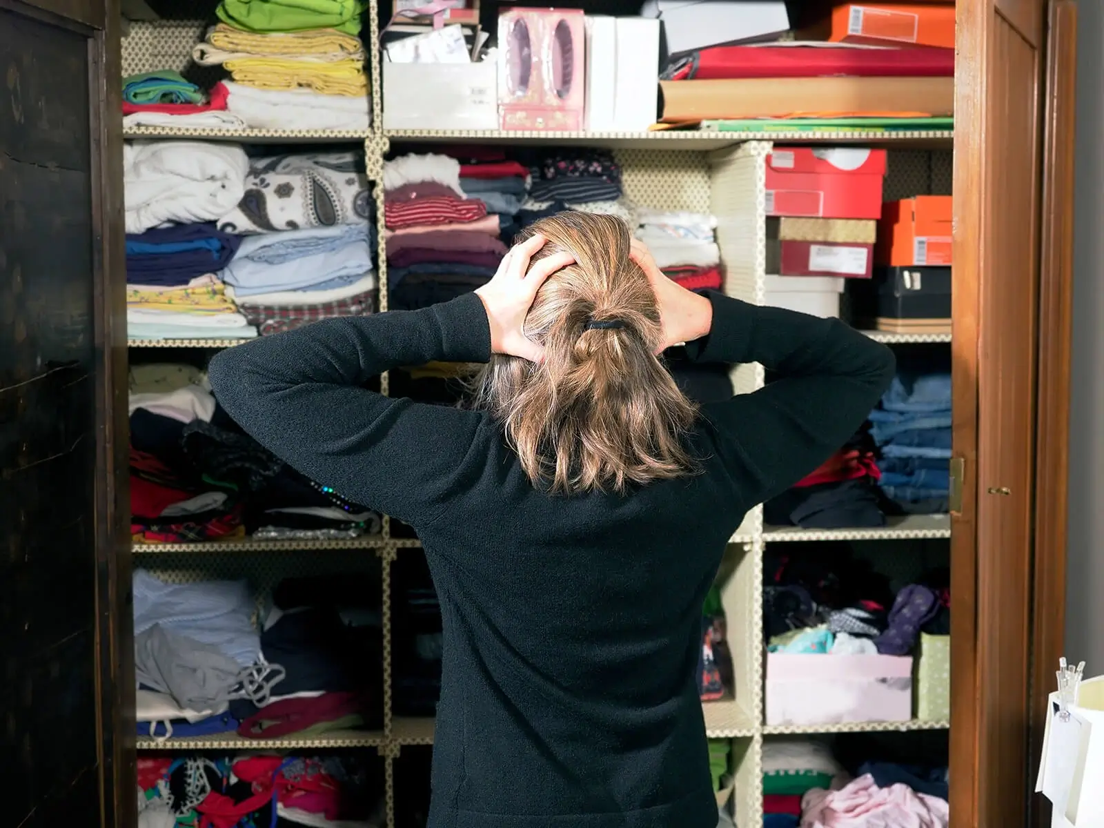 Frustrated woman looking at messy closet