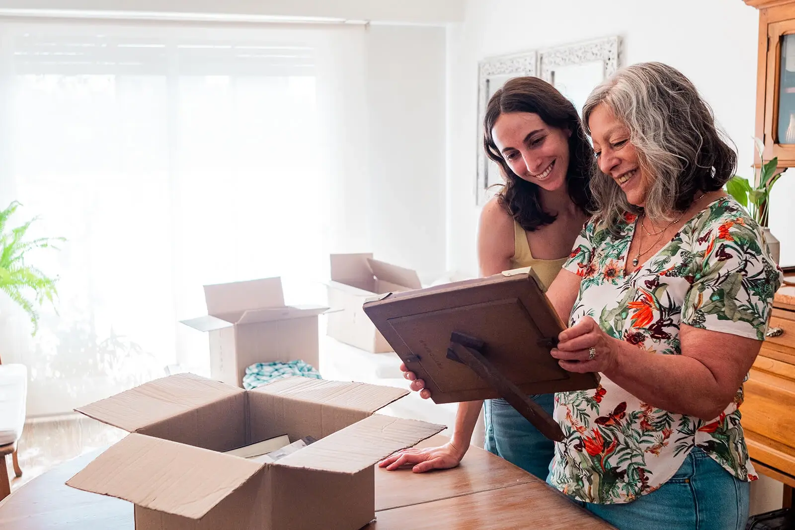 Adult daughter helping older mother pack